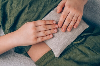 Ein Junge benutzt ein Körnerkissen am Bauch